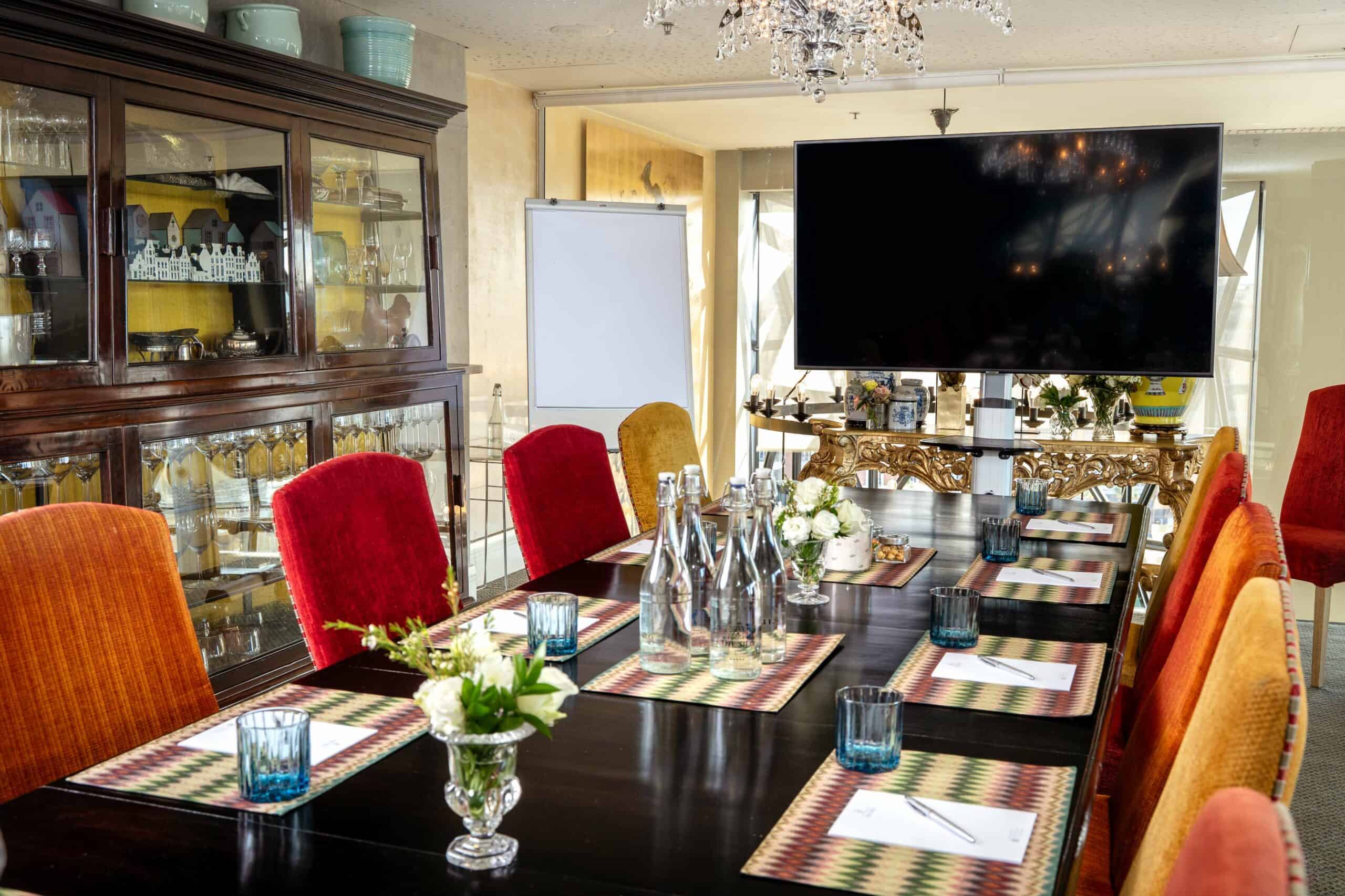 The Wisdom Room, boardroom set with a large plasma screen and whiteboard, ready for the day’s work